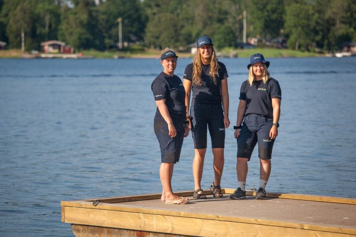 tre anställda på kajak och uteliv på bryggan